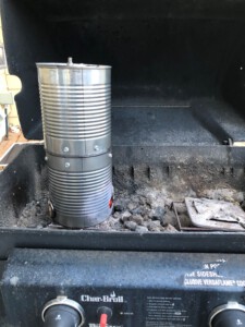 DIY Tin Can Smoker sitting inside a propane BBQ